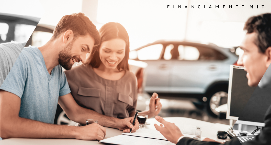 Um homem e uma mulher estão sentados à mesa assinando um contrato de financiamento