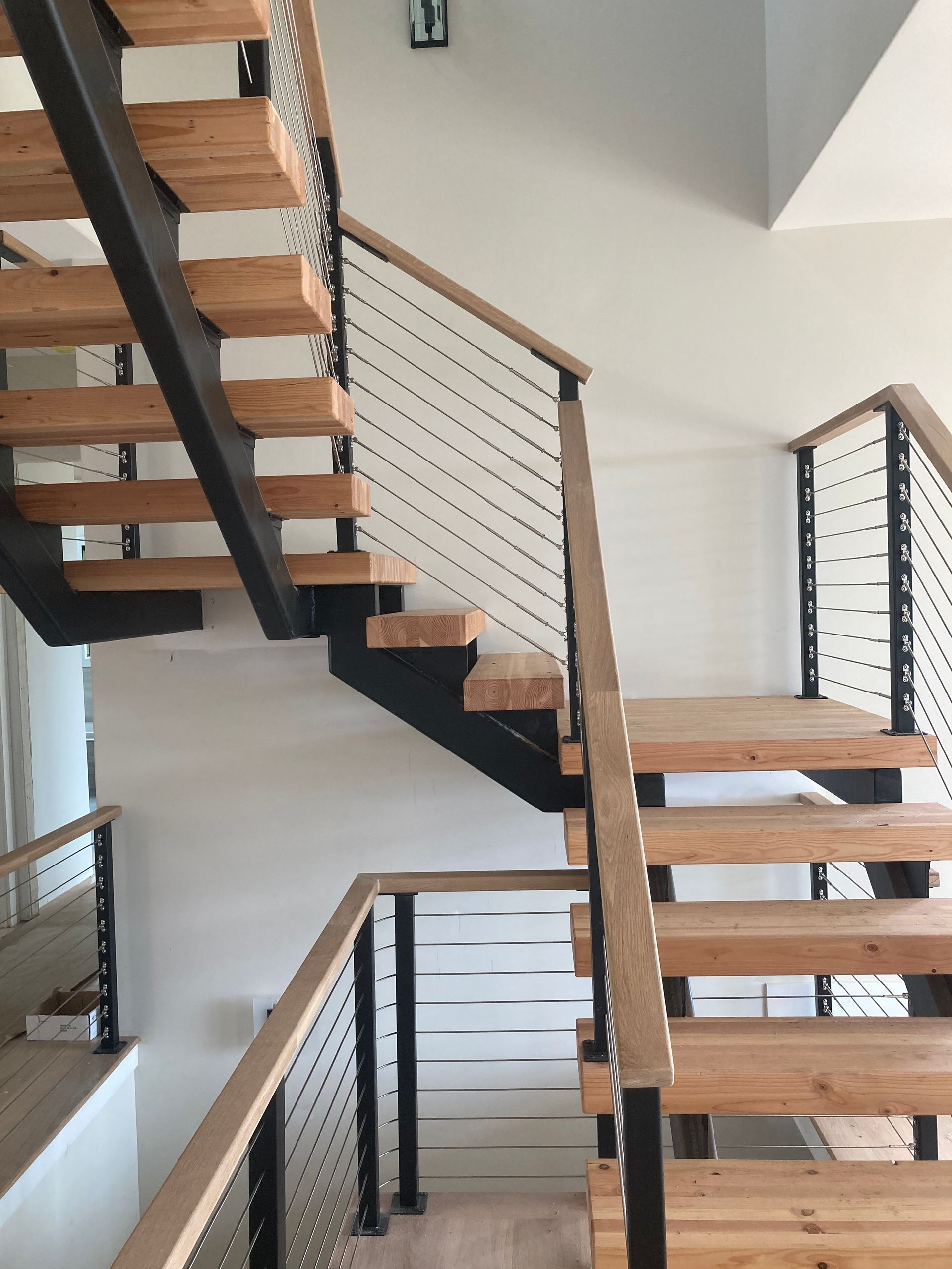 A wooden staircase with a metal railing in a house.