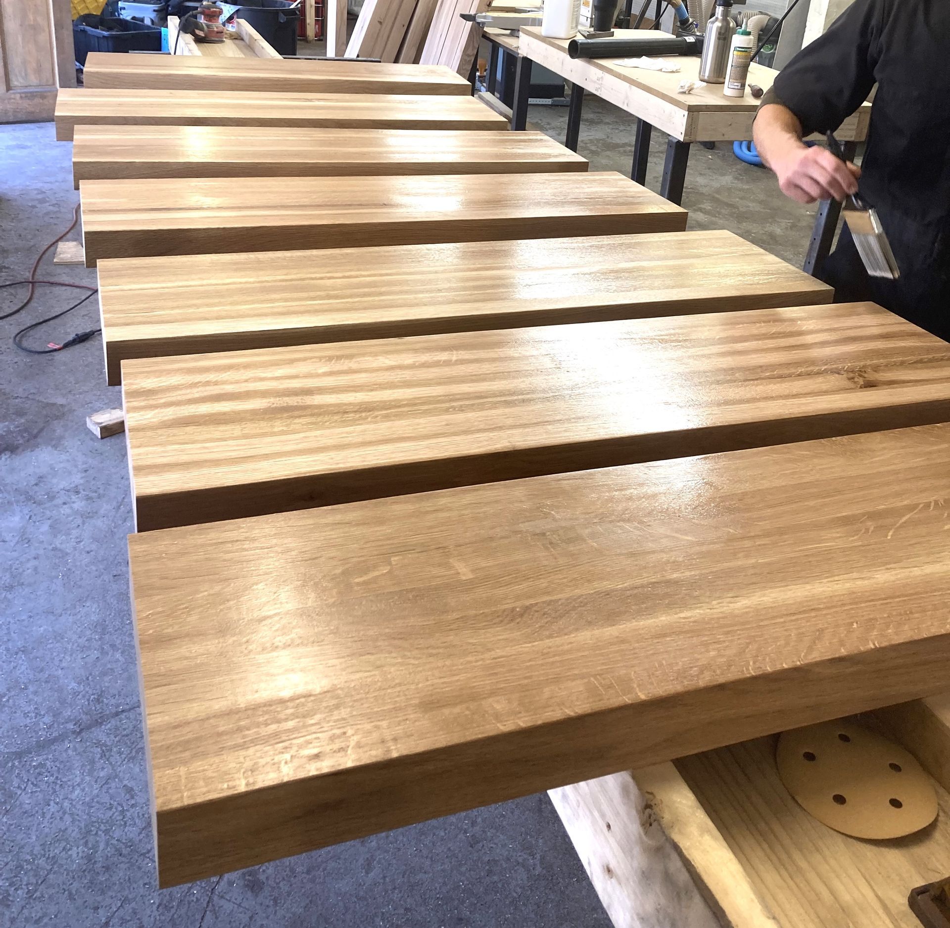 A man is working on a wooden table in a workshop