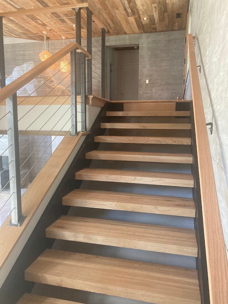 A wooden staircase with a metal railing in a house.