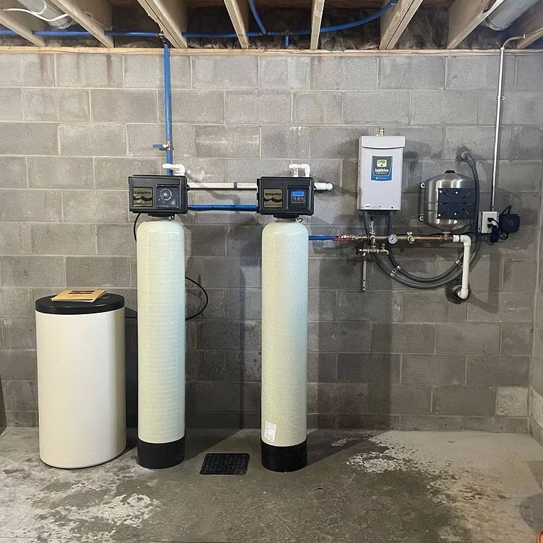 Water filtration system against a gray cinder block wall.