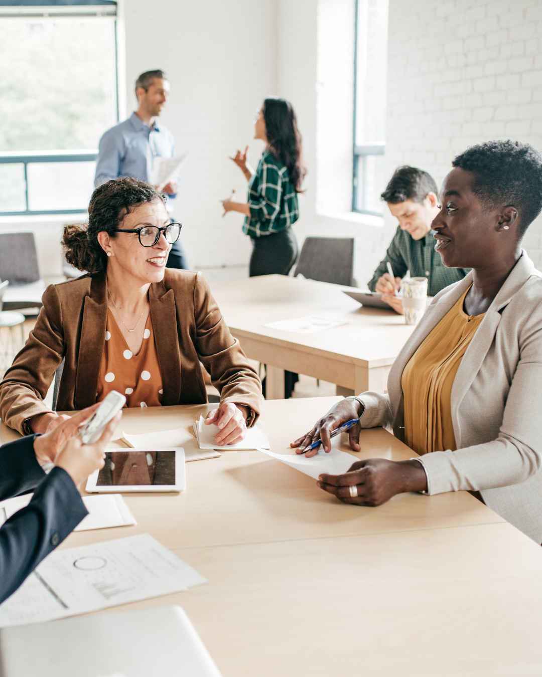 A group of people are sitting around a table having a meeting.