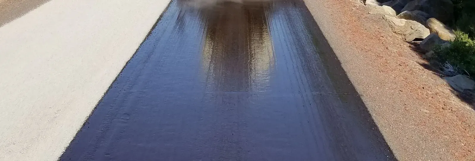 A person is walking down a road with a black tarp on it.