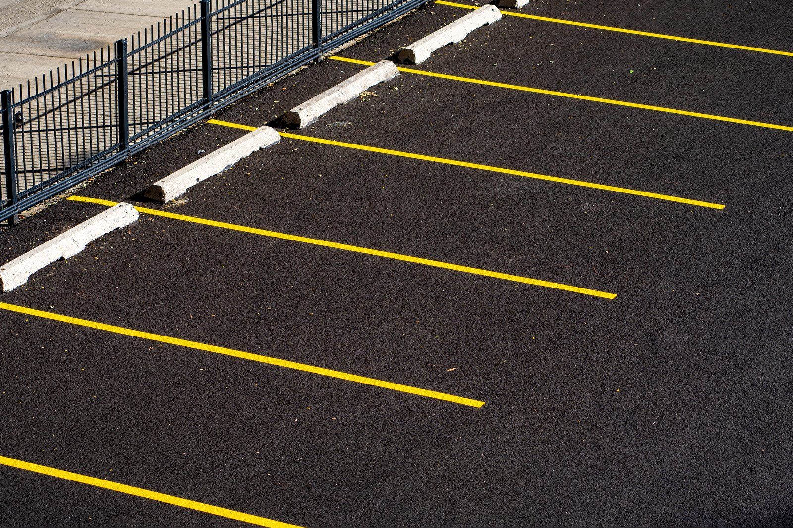 A parking lot with yellow lines and white curbs