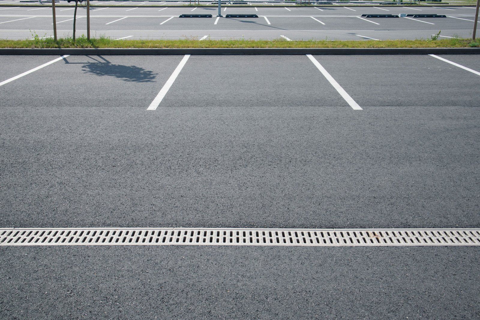 An empty parking lot with a drain in the middle of it.