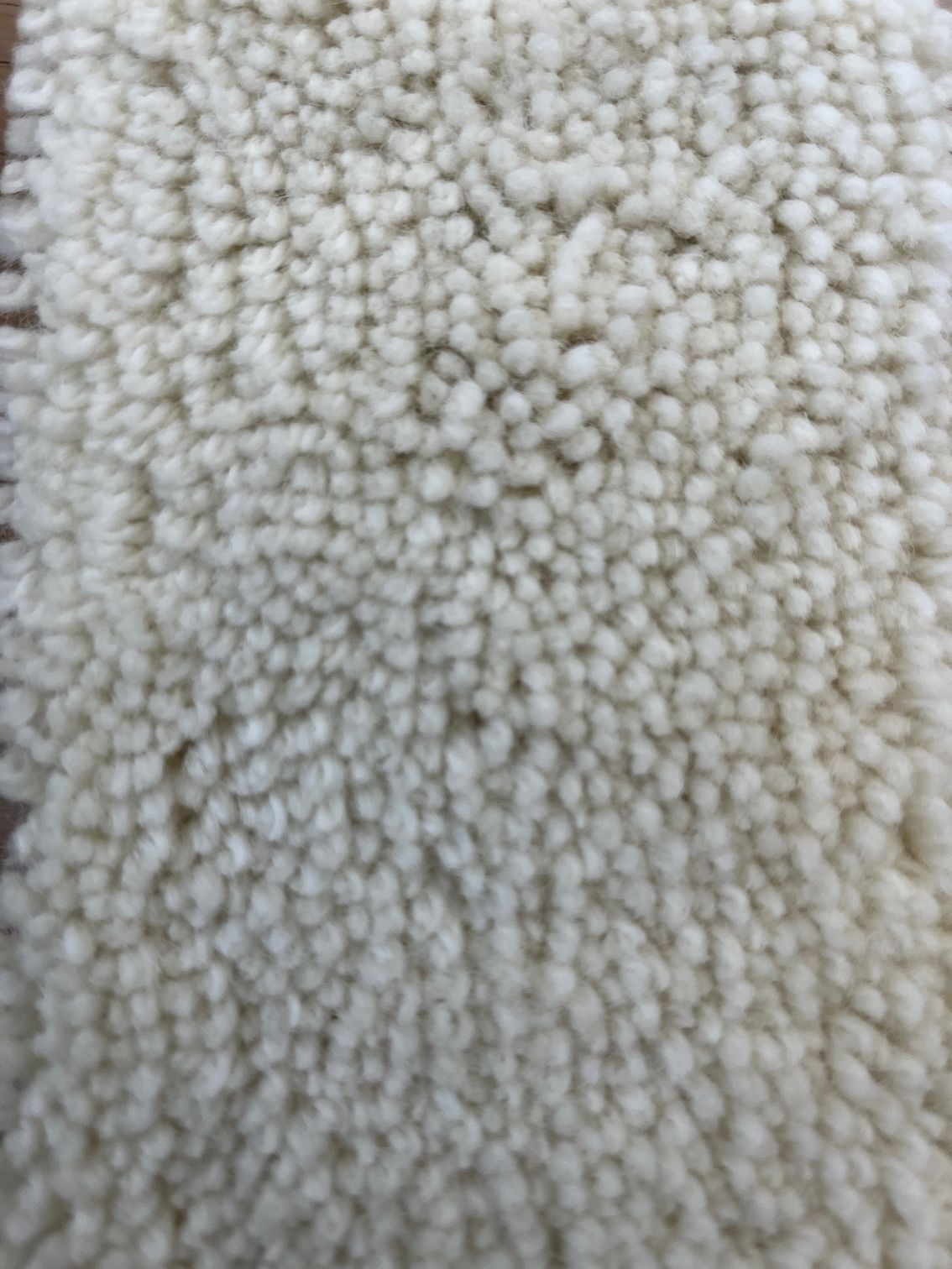 Close-up of a cream-colored, textured rug.