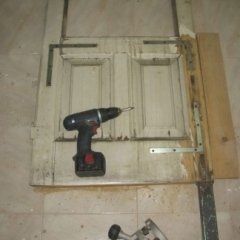 una vecchia porta in legno con un trapano poggiato sopra