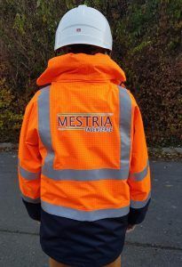 Une personne portant un casque de sécurité et une veste de sécurité orange.