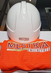Un casque blanc est posé sur une chemise orange.