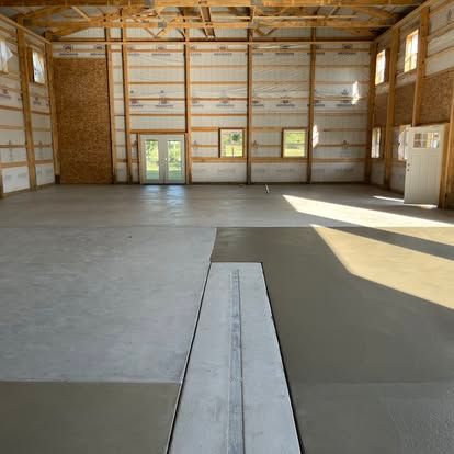 Interior of a large unfinished building with concrete floor and a central drain. Interior of a large unfinished building with concrete floor and a central drain.