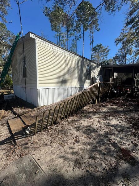 Mobile home with wooden ramp for accessibility. 
