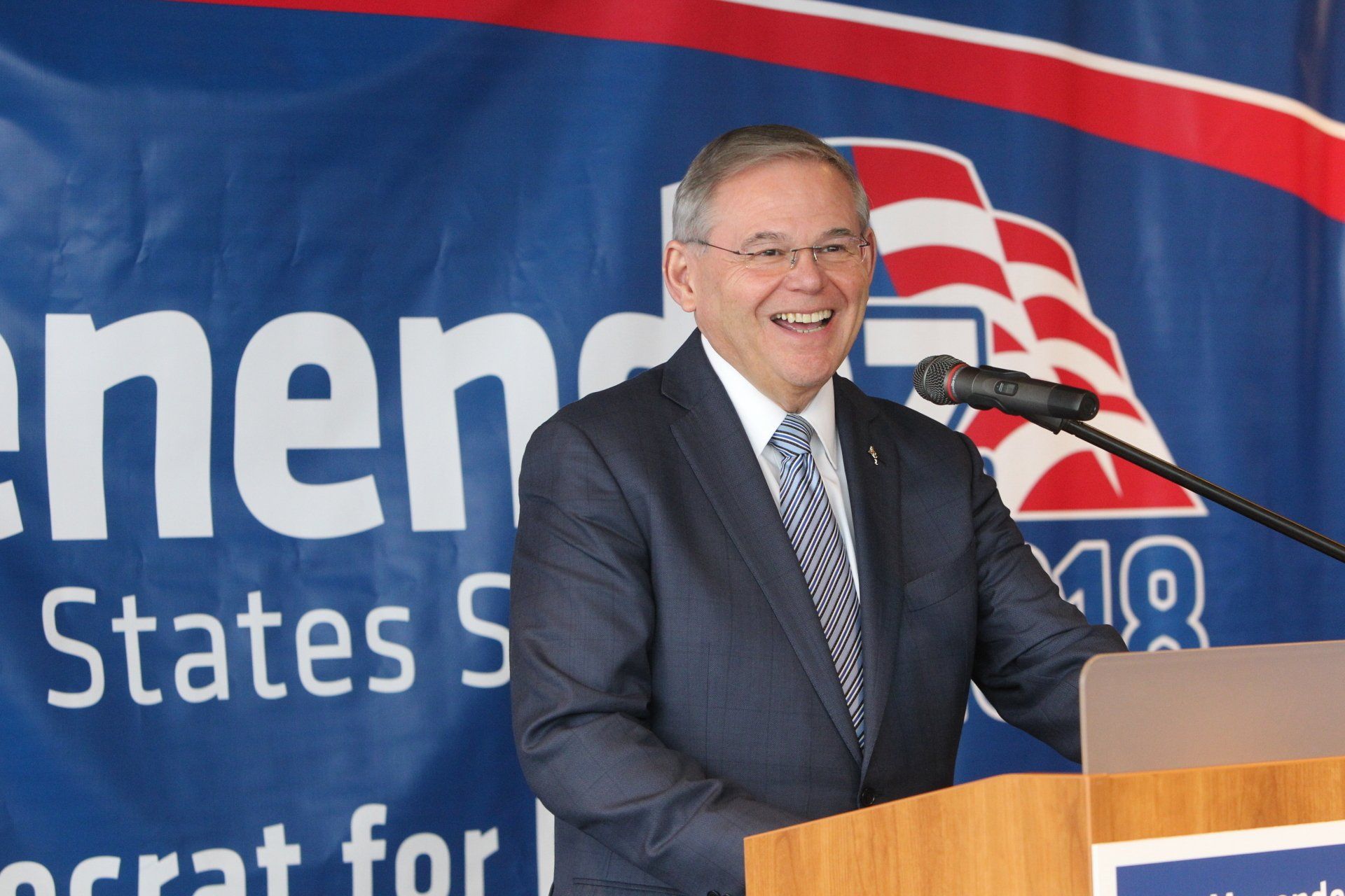 A man stands at a podium in front of a sign that says states