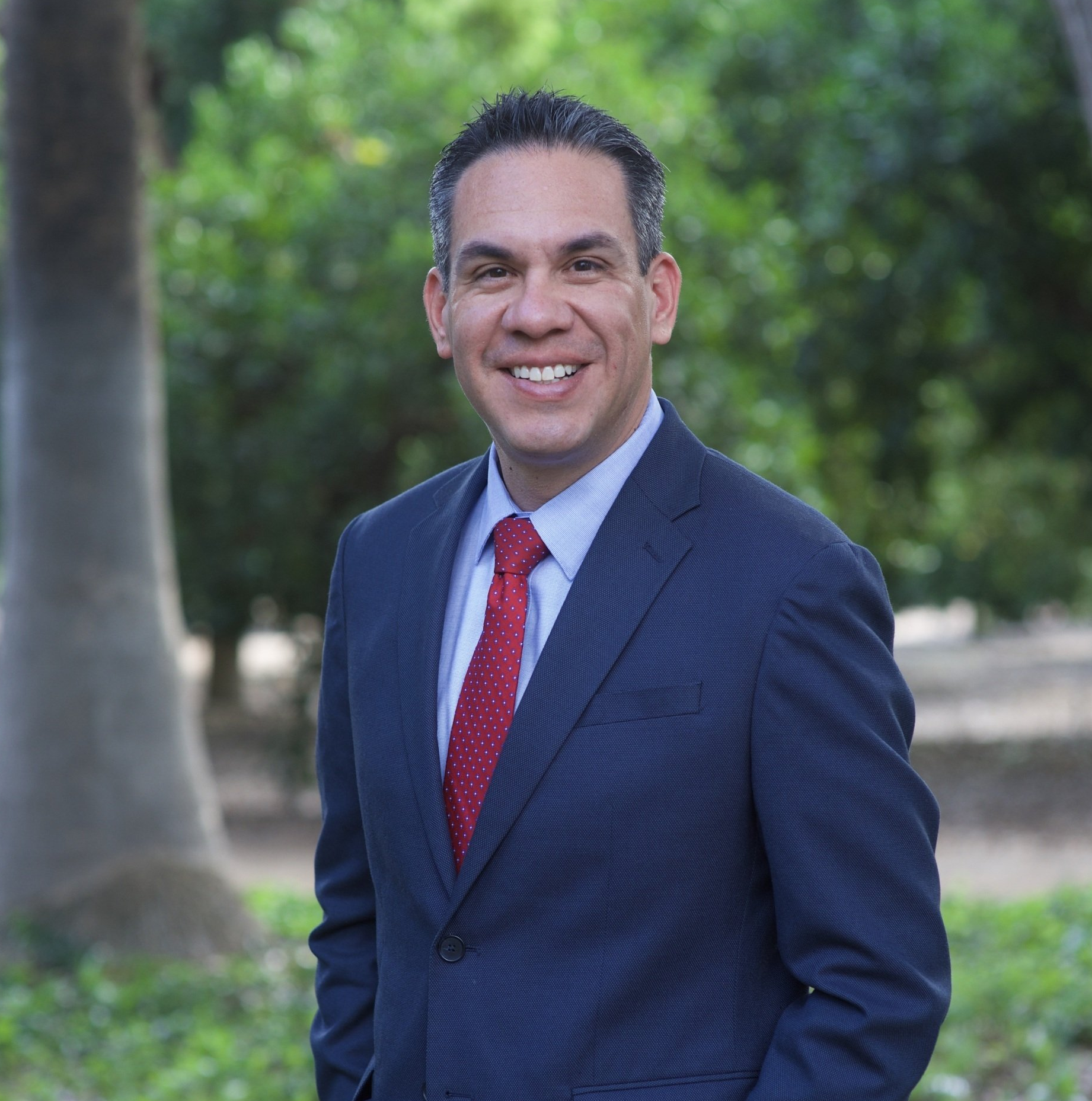 A man in a suit and tie is smiling for the camera.