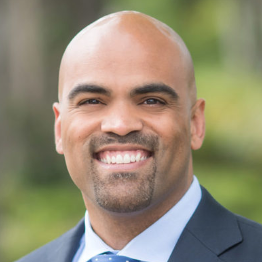 A man in a suit and tie is smiling for the camera.