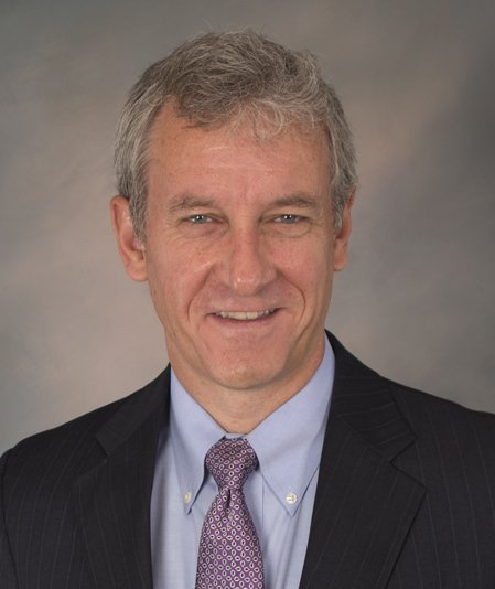 A man in a suit and tie smiles for the camera