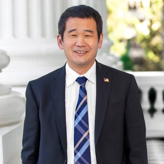 A man in a suit and tie is smiling for the camera