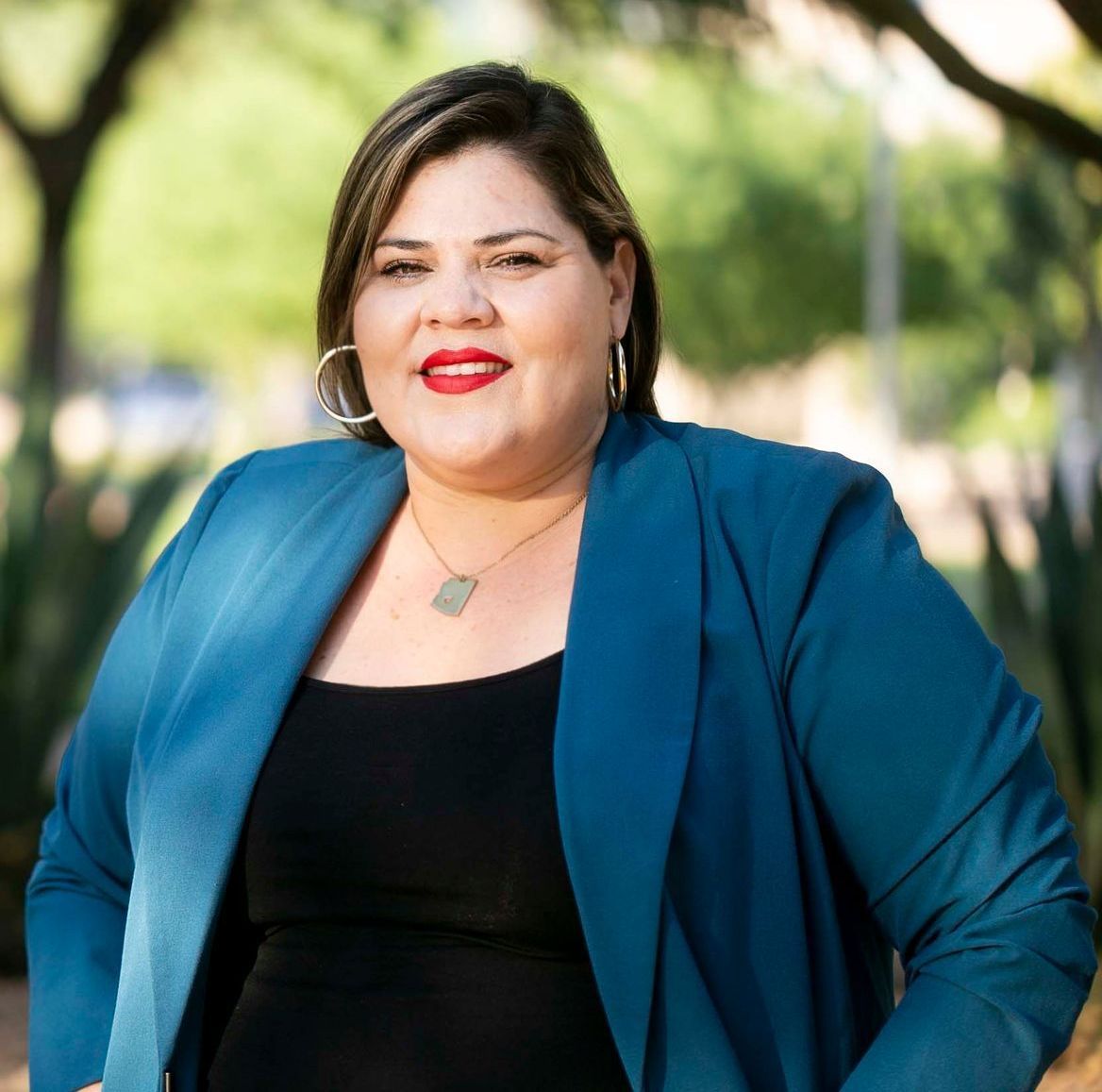 A woman is wearing a blue jacket and a black top.