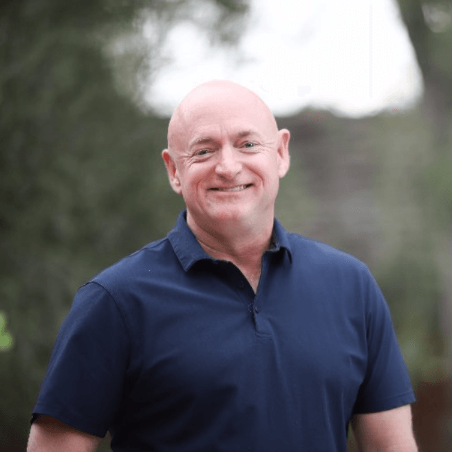 A bald man in a blue shirt is smiling for the camera.