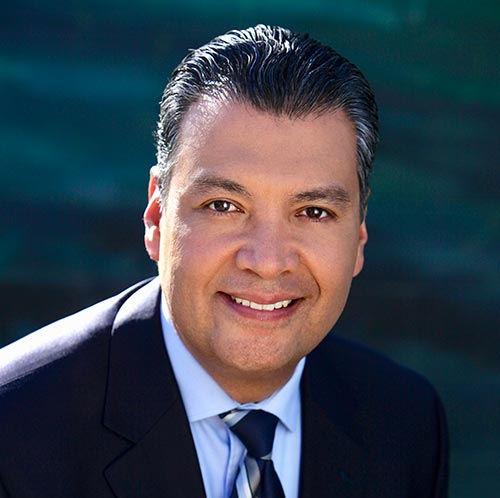 A man in a suit and tie is smiling for the camera.
