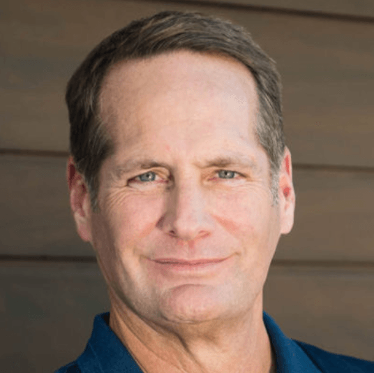 A man in a blue shirt is smiling for the camera.