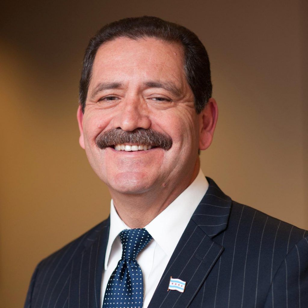 A man with a mustache is wearing a suit and tie