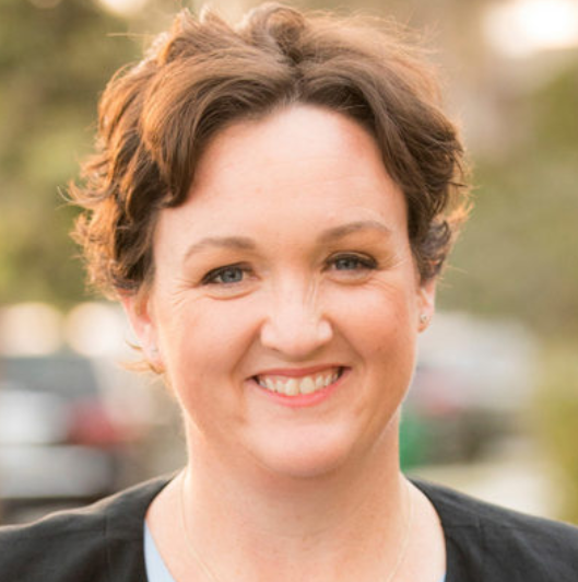 A woman with short brown hair is smiling for the camera.