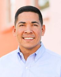 A man in a blue shirt is smiling for the camera.