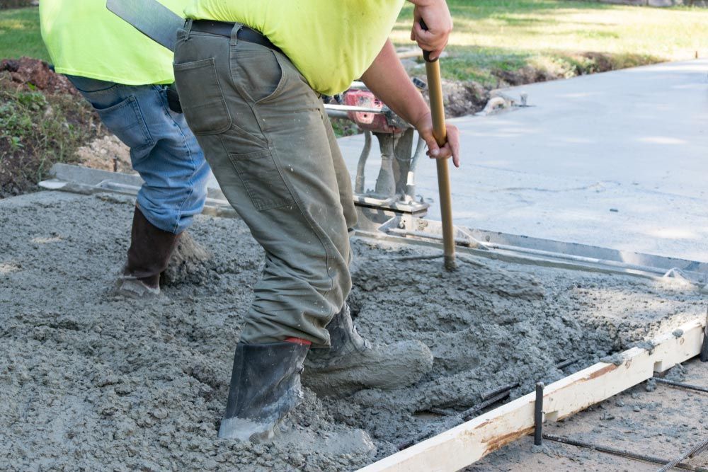 Men Pouring And Finishing A Concrete Slab Driveway With A Wet Clement Mix — Selling Quality Building Products in Tamworth, NSW