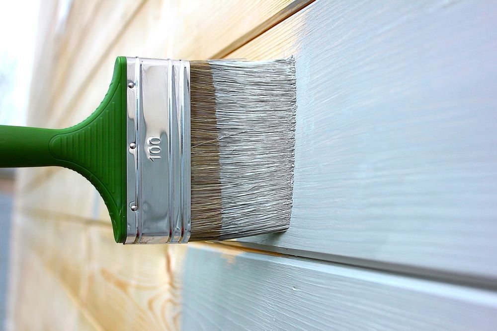Green Brush Paints The Boards Of A Wooden Wall — Top-Quality Building Supplies in Tamworth, NSW