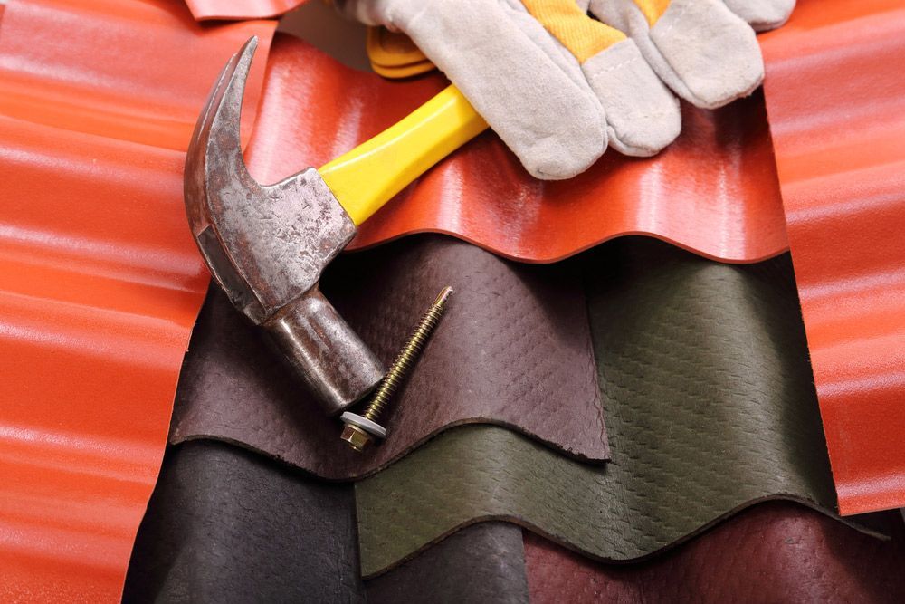 The Roofs Of Various Solid Materials And A Hammer And A Screw Fixing — Building Supplies in Narrabri, NSW