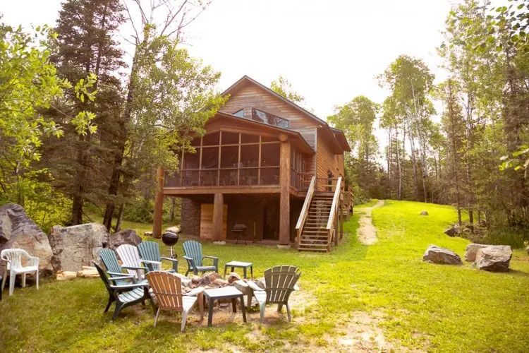 A house with a screened in porch and a fire pit in front of it