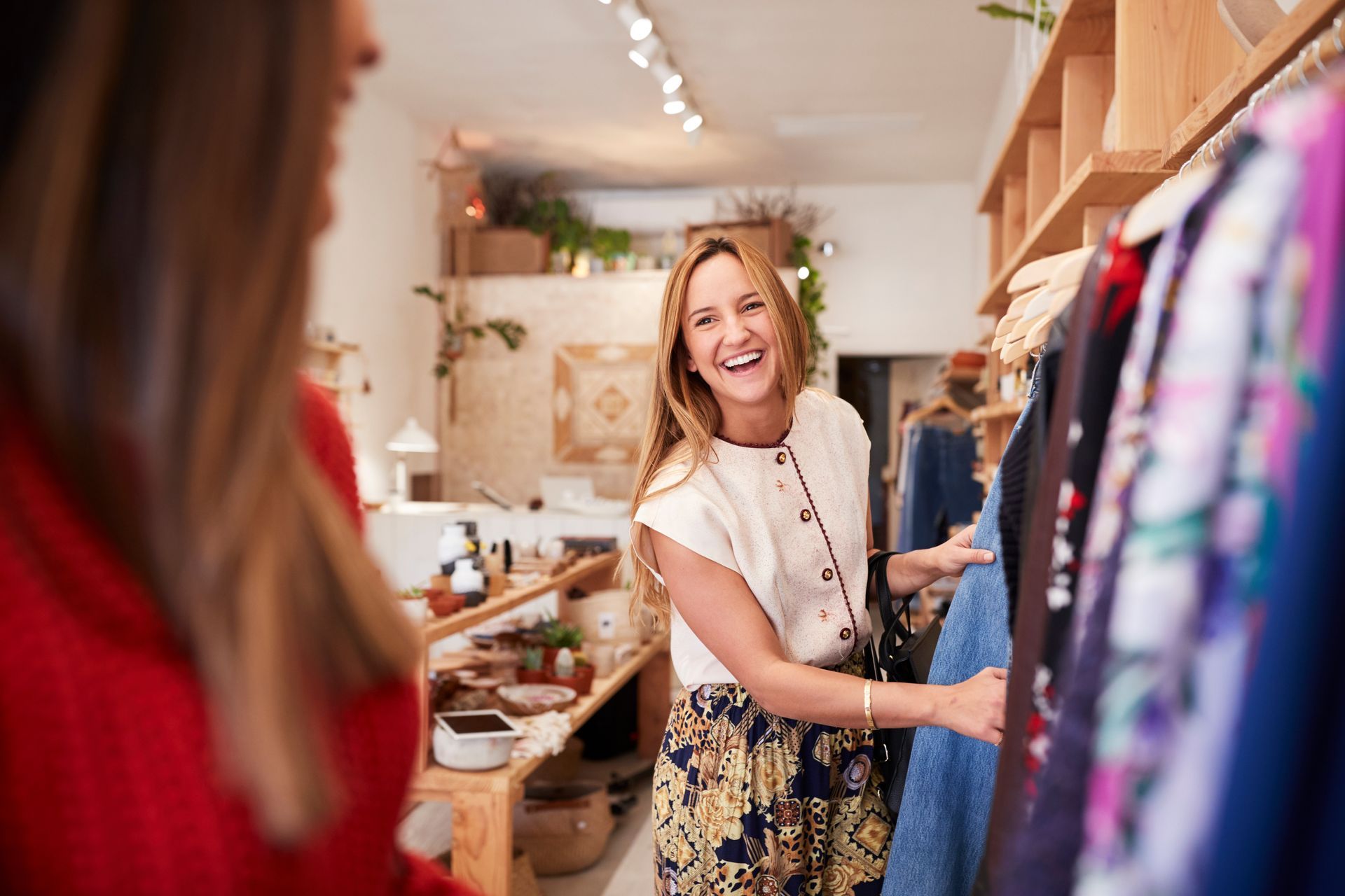 Two women are shopping in a clothing store.