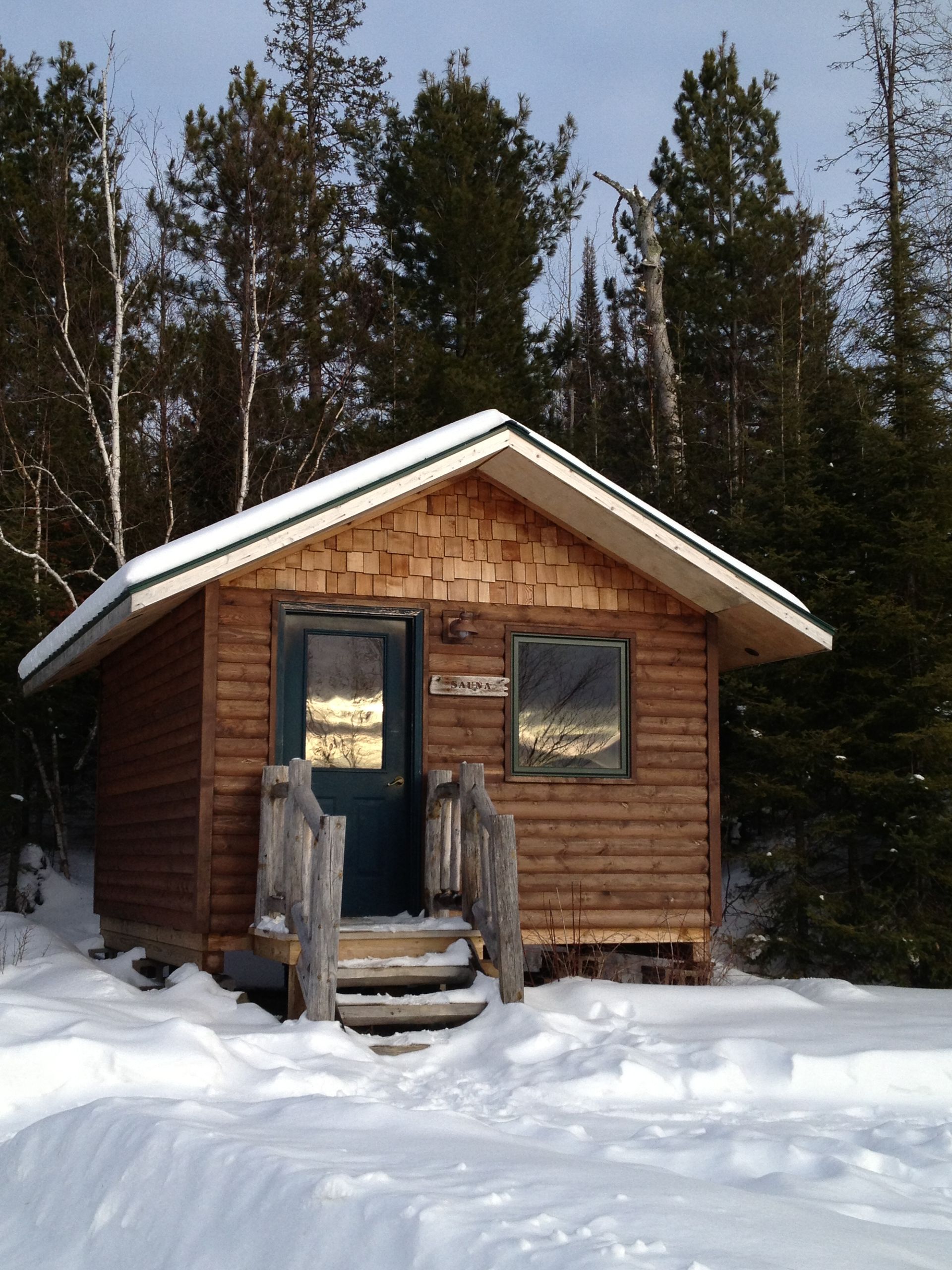 A small wooden cabin in the middle of a snowy forest