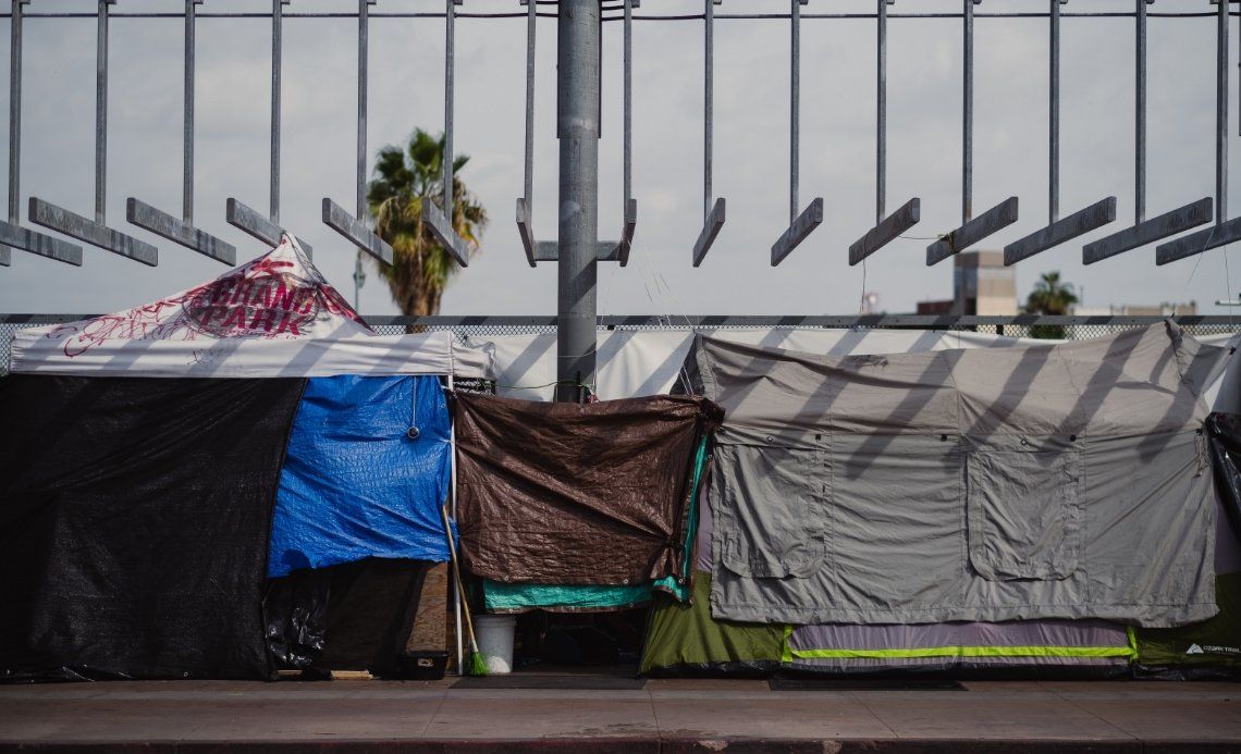 A group of tents sitting next to each other under a bridge.