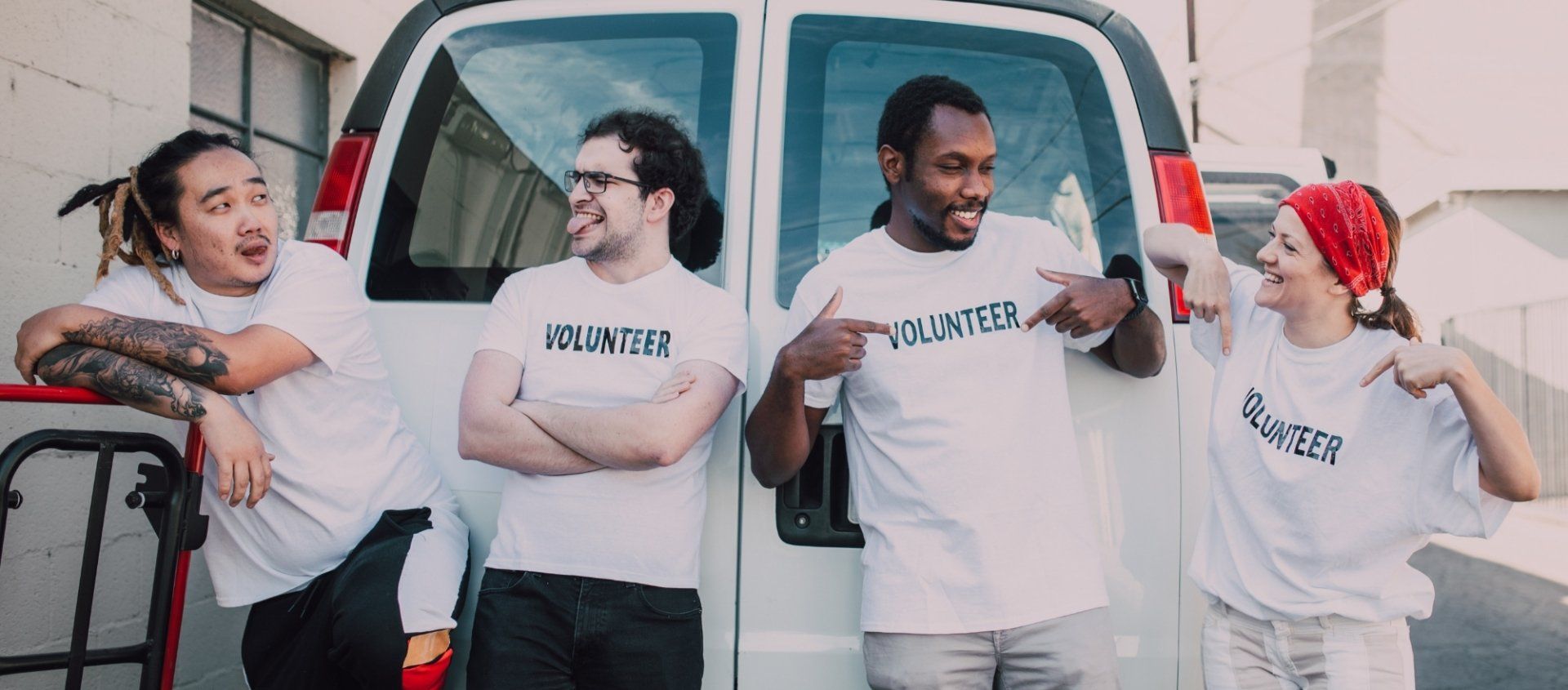 A group of people are standing in front of a white van.