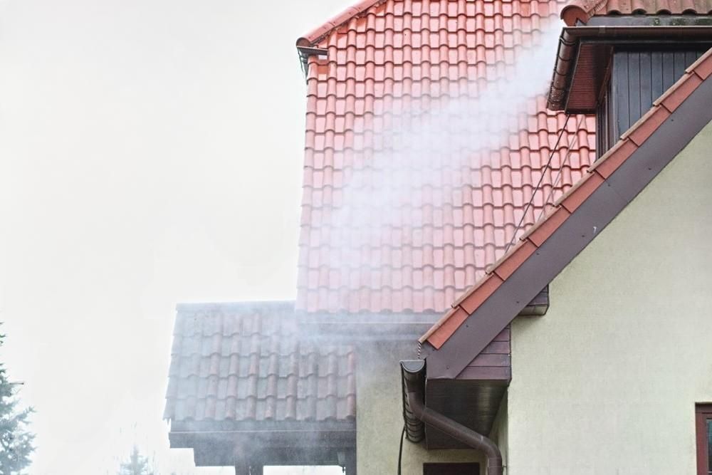 Smoke is coming out of the roof of a house.