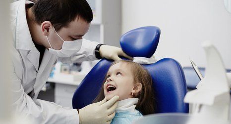 dentist checking kid's teeth