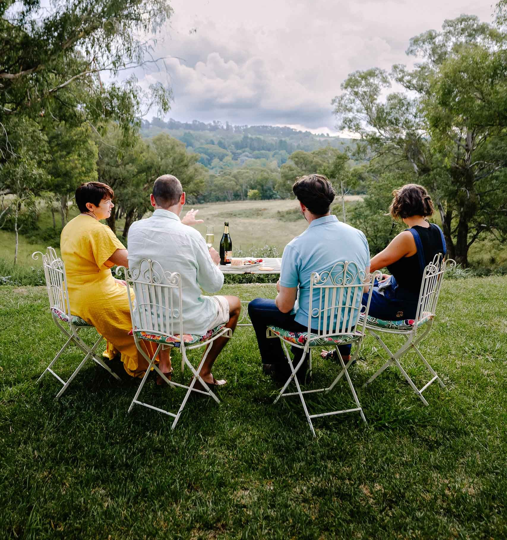 A Woman in a White Robe is Holding a Bottle of Champagne and Balloons — Lakeview Luxury Retreat in Canobolas, NSW