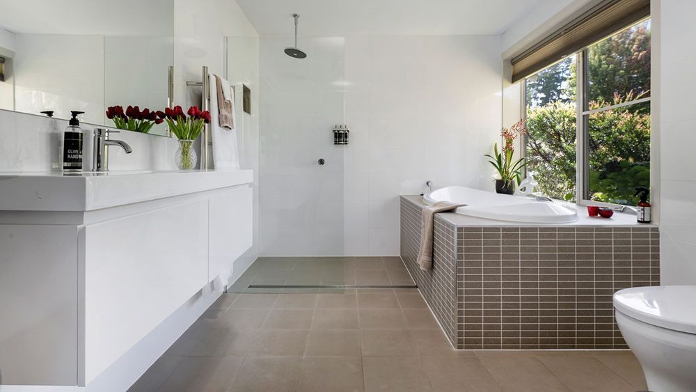 A Bathroom With a Tub, Sink and Toilet — Lakeview Luxury Retreat in Canobolas, NSW