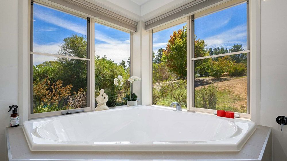 A Bathroom With a Jacuzzi Tub and Two Windows — Lakeview Luxury Retreat in Canobolas, NSW