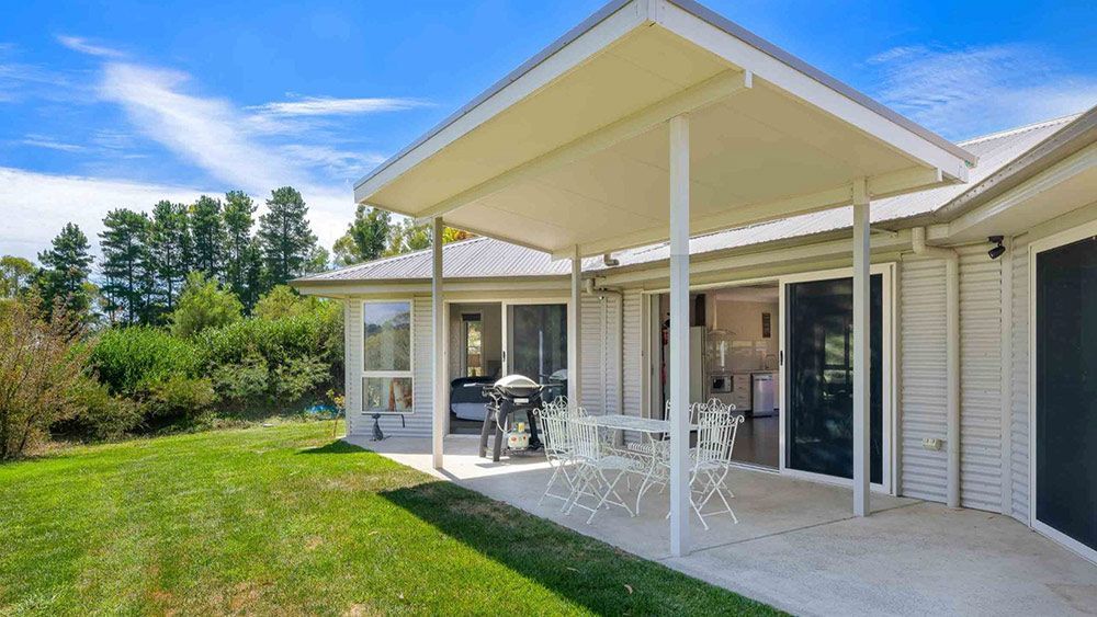 A White House With a Covered Patio and a Table and Chairs — Lakeview Luxury Retreat in Canobolas, NSW