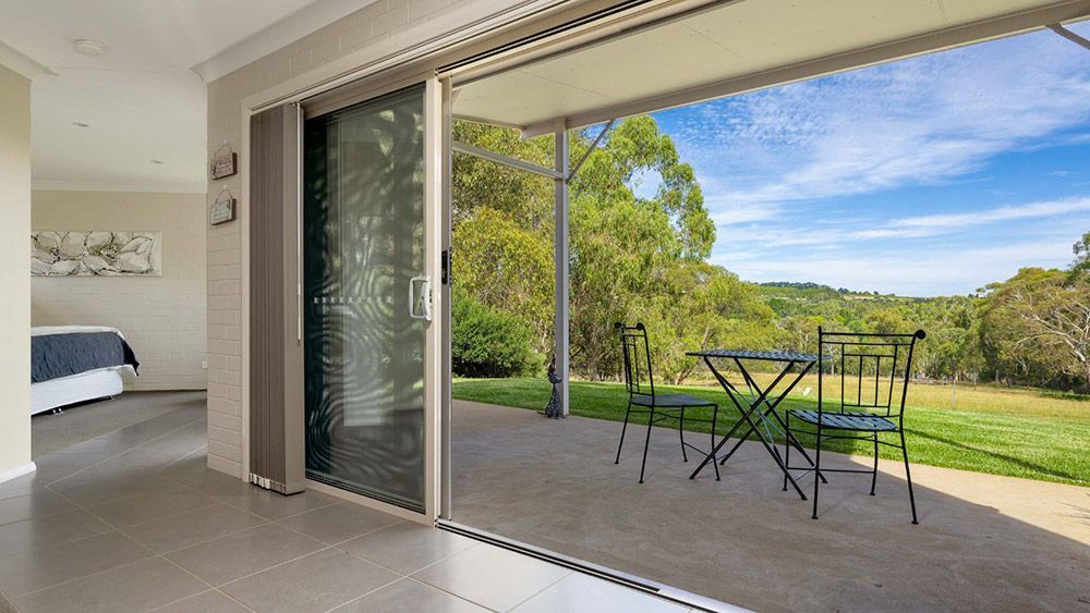There is a Table and Chairs on the Porch of a House — Lakeview Luxury Retreat in Canobolas, NSW