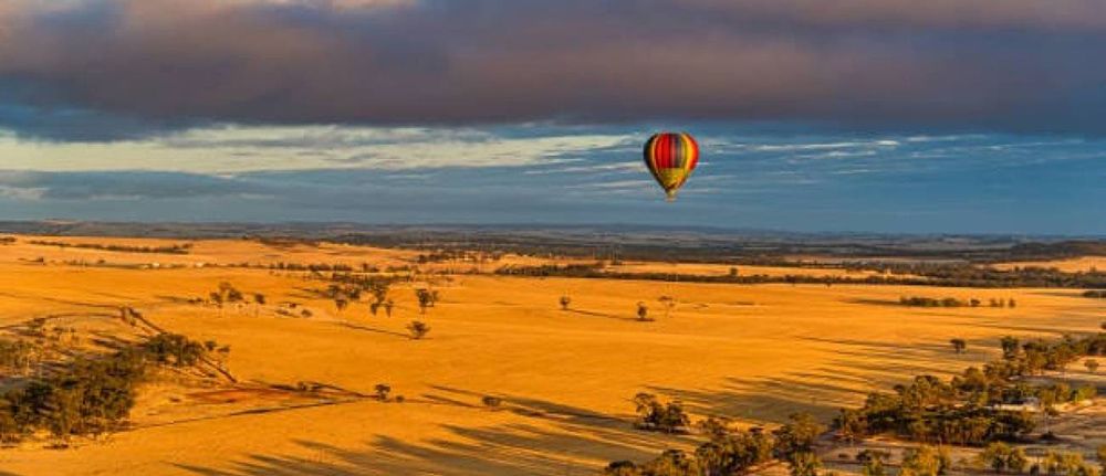 A Hot Air Balloon is Flying Over a Desert Landscape — Lakeview Luxury Retreat in Canobolas, NSW