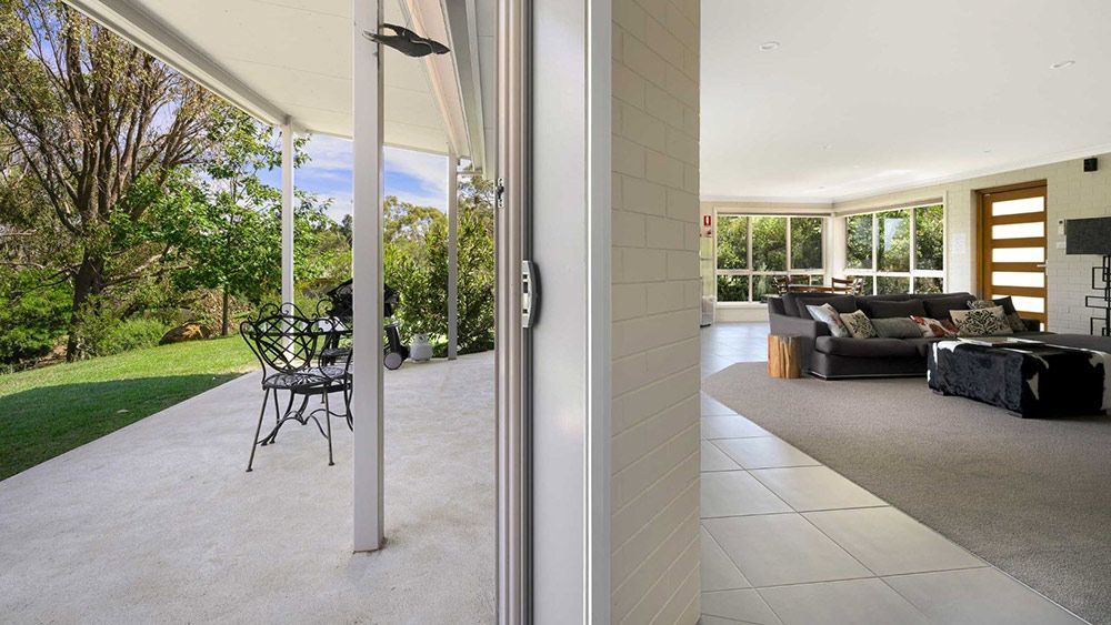 A Living Room With a Sliding Glass Door Leading to a Patio — Lakeview Luxury Retreat in Canobolas, NSW
