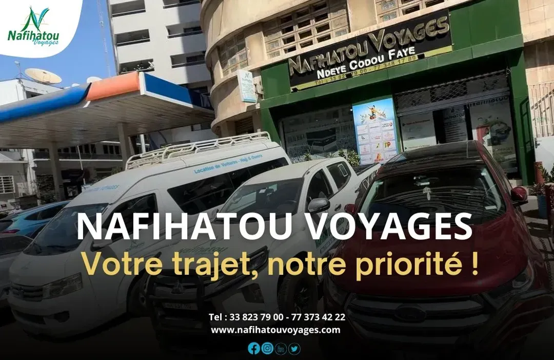 Façade de l'agence de voyages Nafihatou Voyages. Voitures garées devant. Véhicules blancs, dorés et rouges.