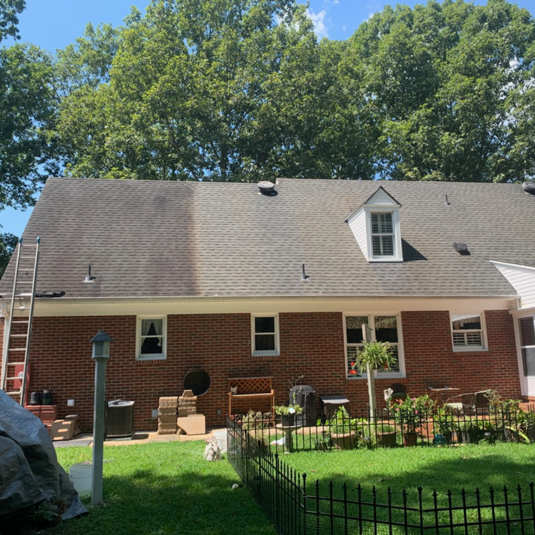 Man on Ladder Cleaning House Roof with High Pressure Washer — Midlothian, VA — VIRGINIA POWERWASH, INC