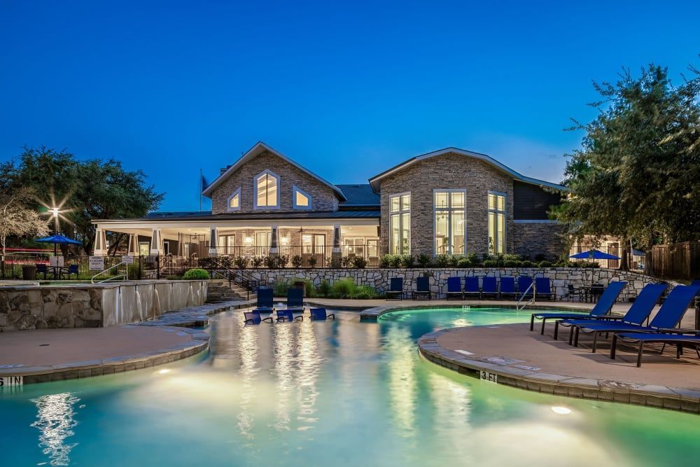 a large swimming pool in front of a large house at Marquis on Lakeline in Cedar Park, TX.
