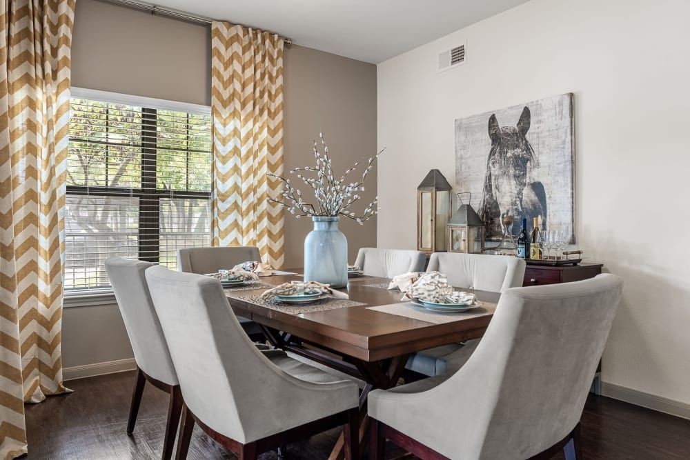a dining room with a table and chairs and a painting of a horse on the wall at Marquis on Lakeline in Cedar Park, TX.