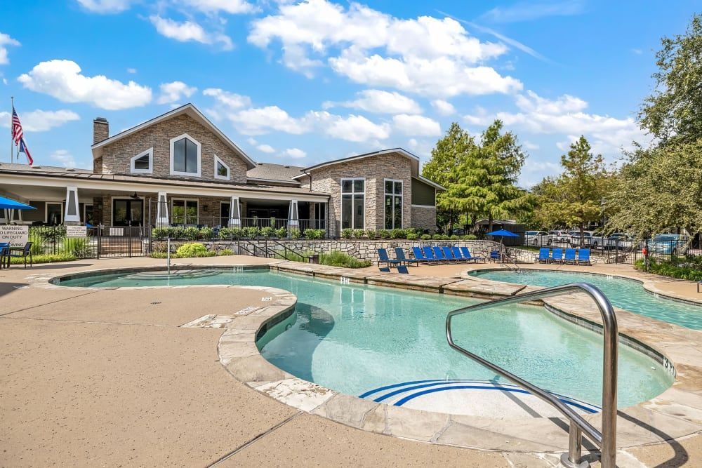 a large swimming pool in front of a large house at Marquis on Lakeline in Cedar Park, TX.
