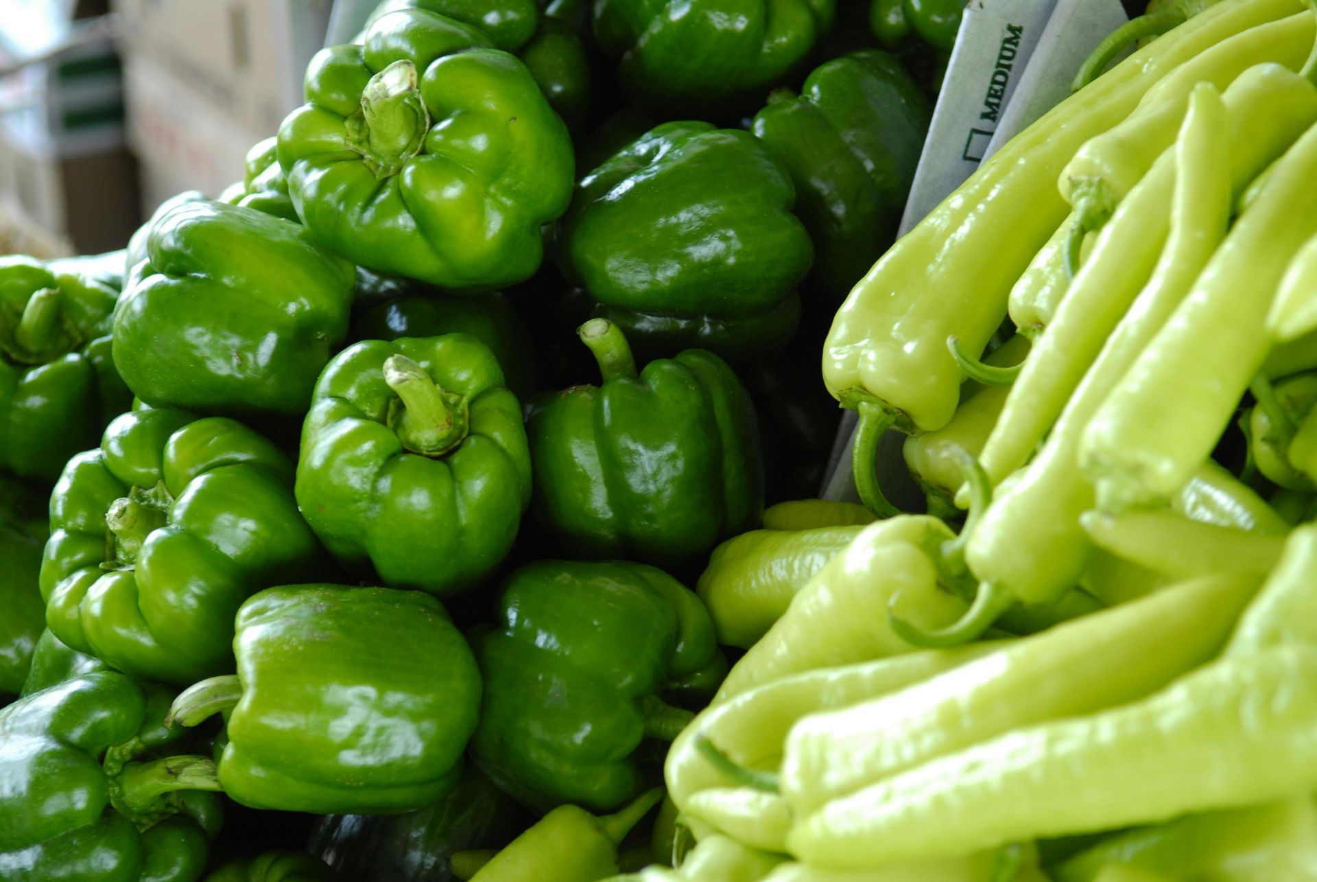 A bunch of green peppers are stacked on top of each other